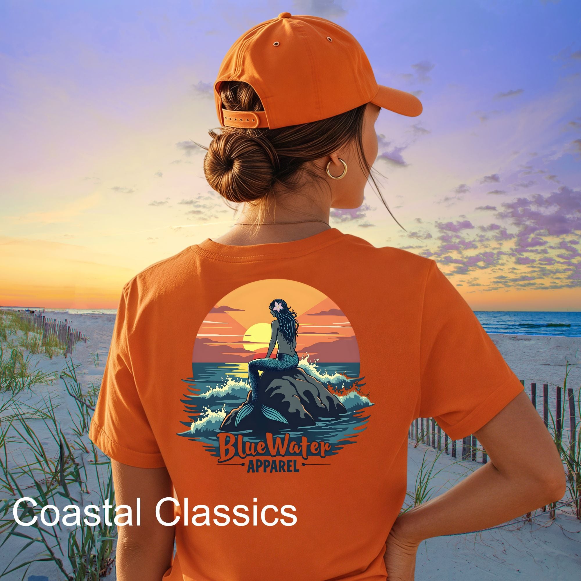 female model wearing orange mermaid sunset tee on sunset beach by blue water apparel
