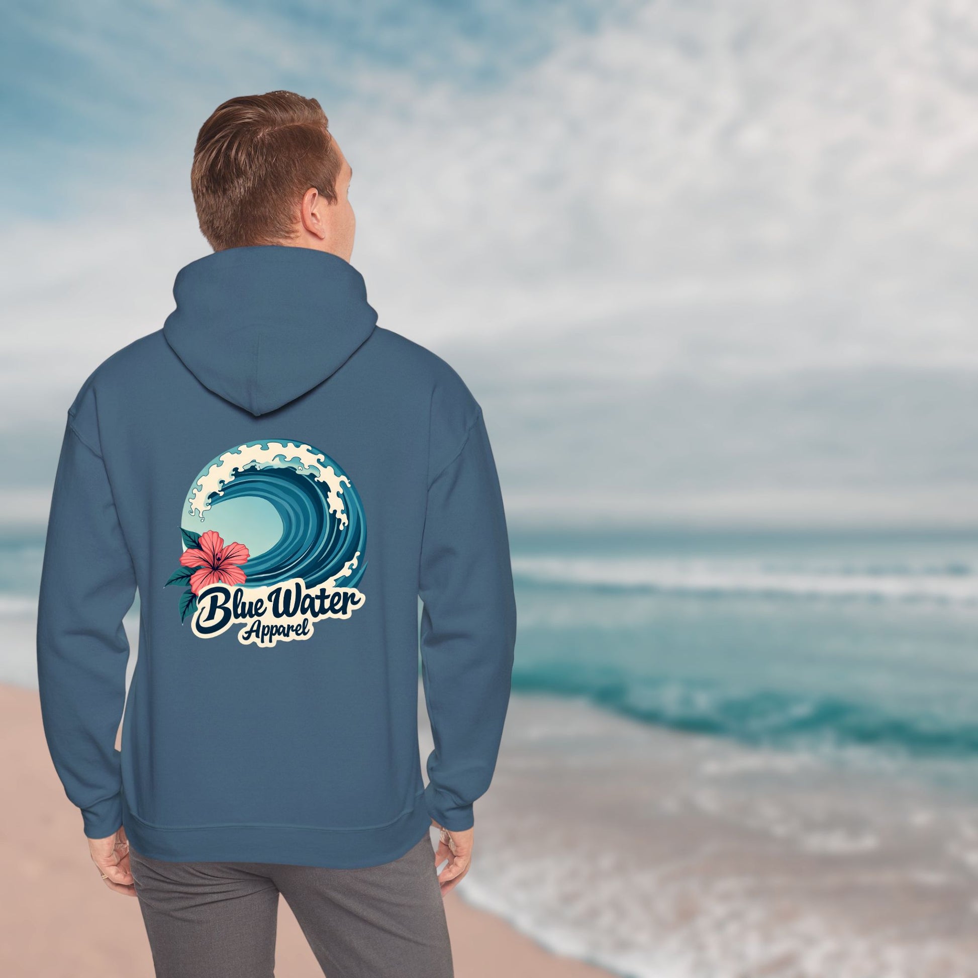 man on beach wearing indigo blue hibiscus wave hoodie by blue water apparel
