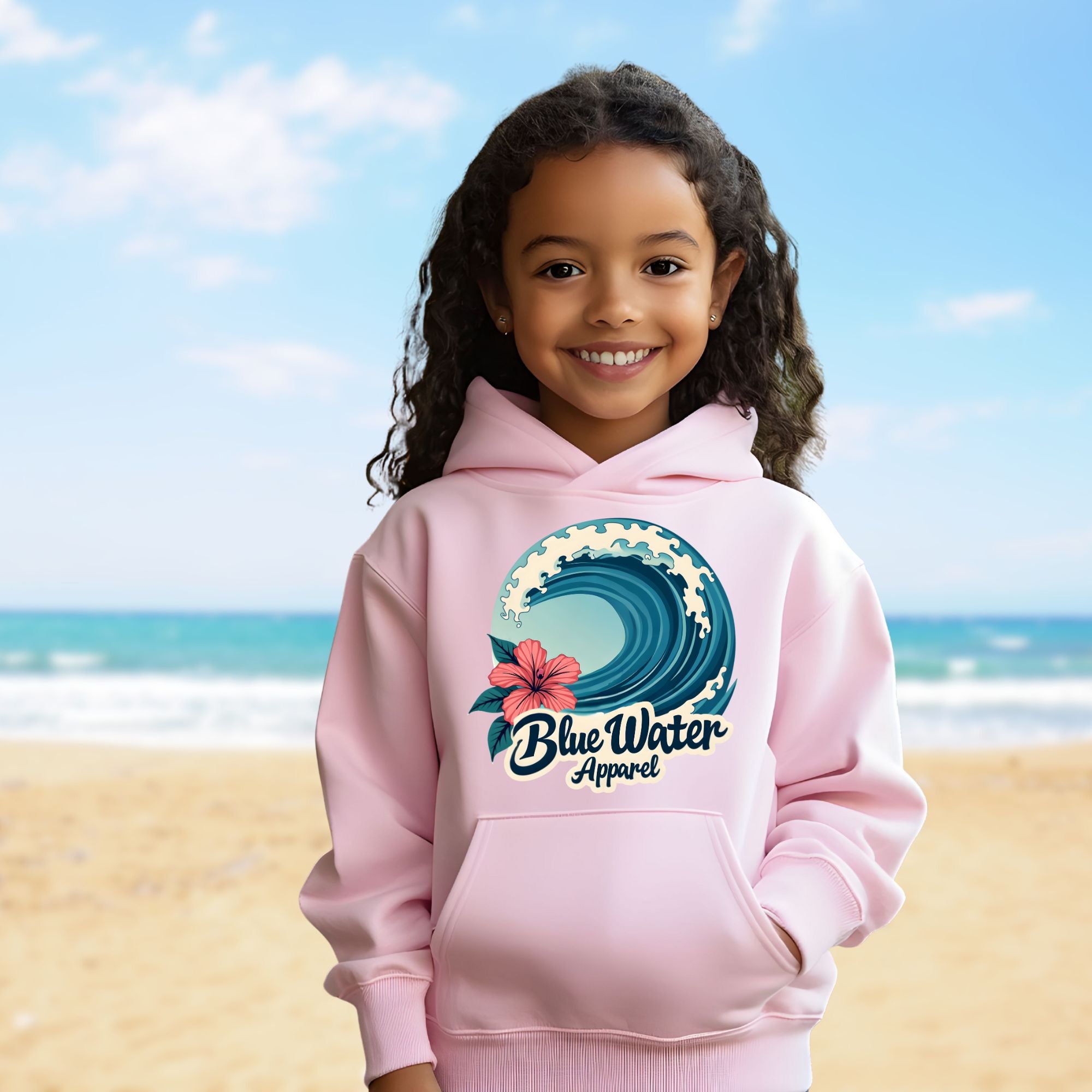 child model on beach wearing light pink hibiscus wave kids hoodie by blue water apparel