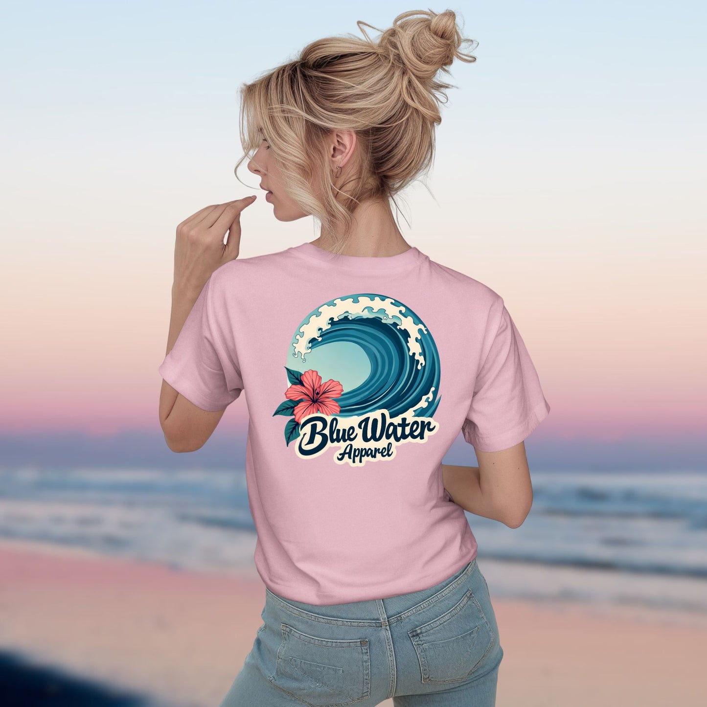 Woman model wearing pink hibiscus wave tee by blue water apparel