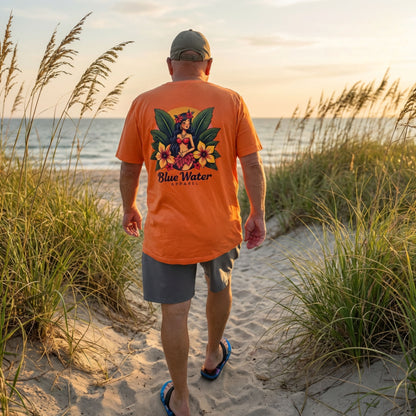 Co-owner of Blue Water Apparel wearing orange island girl tee walking down coastal trail.