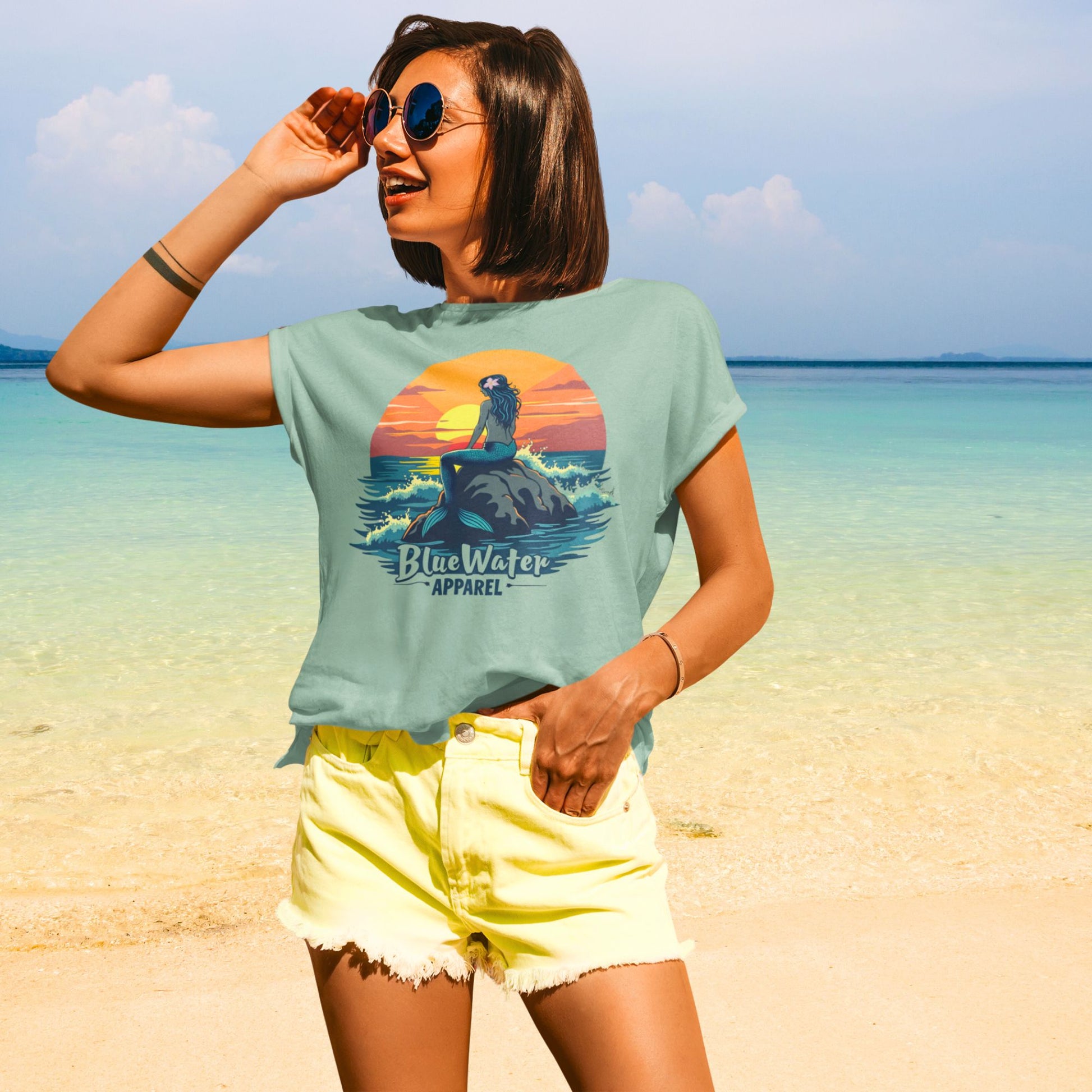 Model on beach wearing sage mermaid sunset tee by blue water apparel