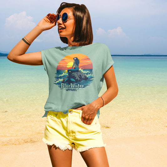Model on beach wearing sage mermaid sunset tee by blue water apparel