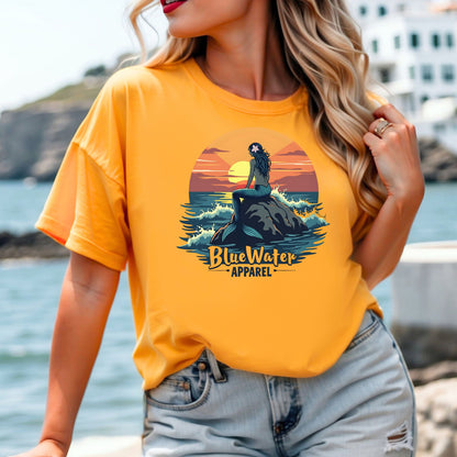 model on shore wearing gold mermaid sunset tee by blue water apparel