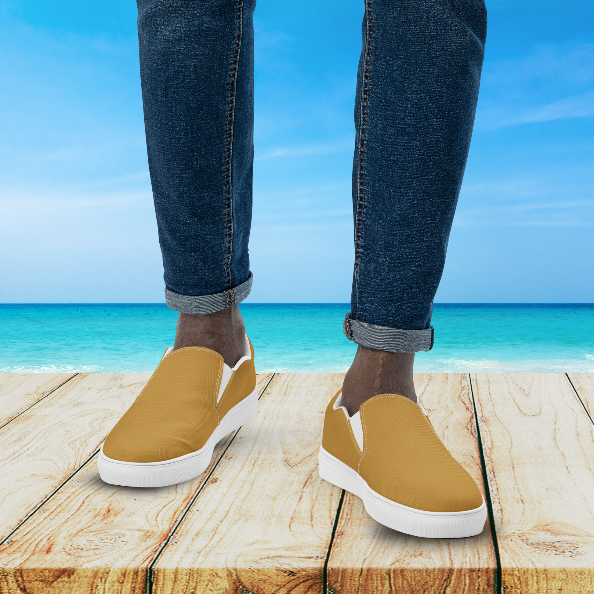 Person wearing mustard yellow shoes with white soles on a wooden platform by the ocean.
