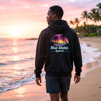 male model wearing black neon sunset adult hoodie on sunset beach by blue water apparel