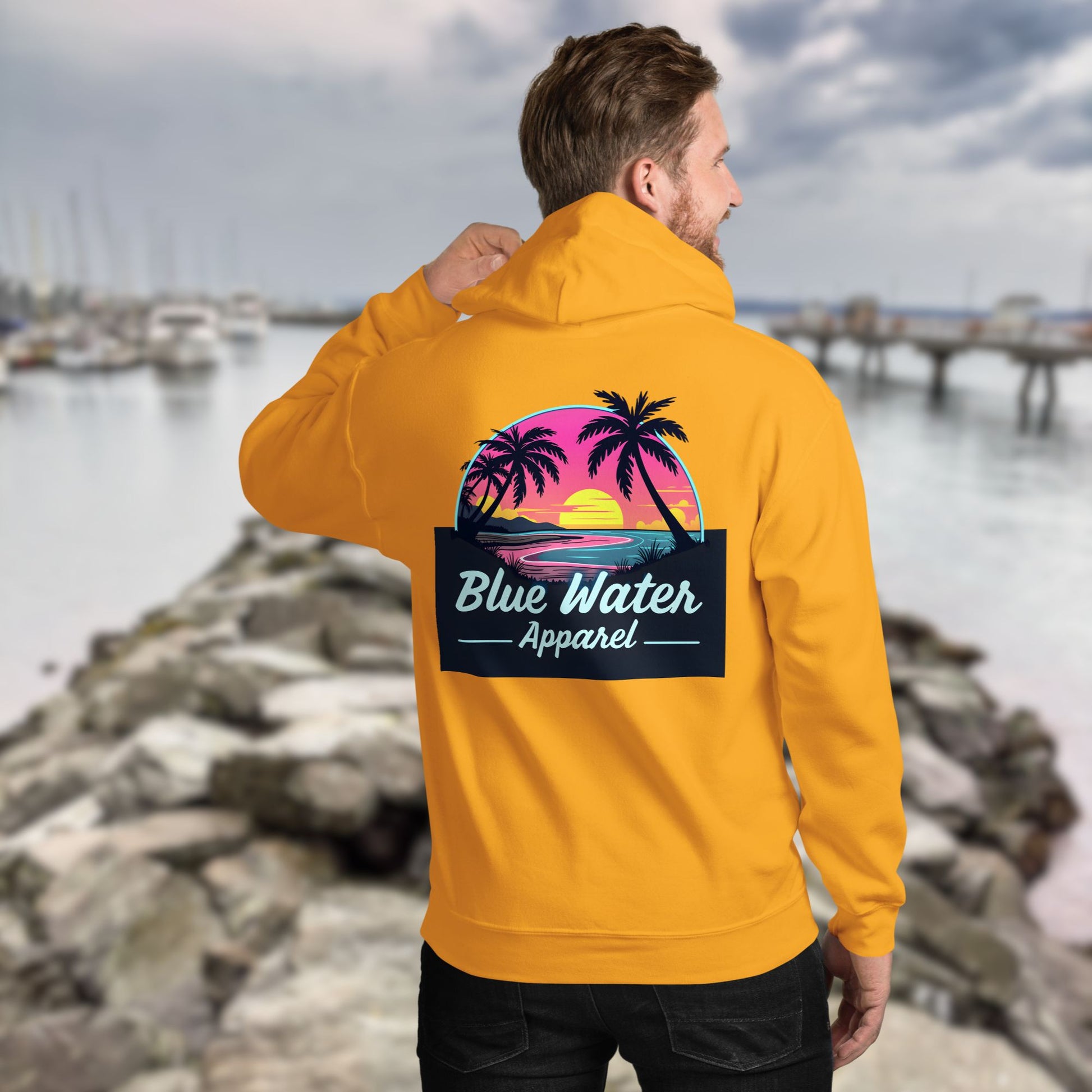 model on jetty wearing gold neon sunset hoodie by blue water apparel