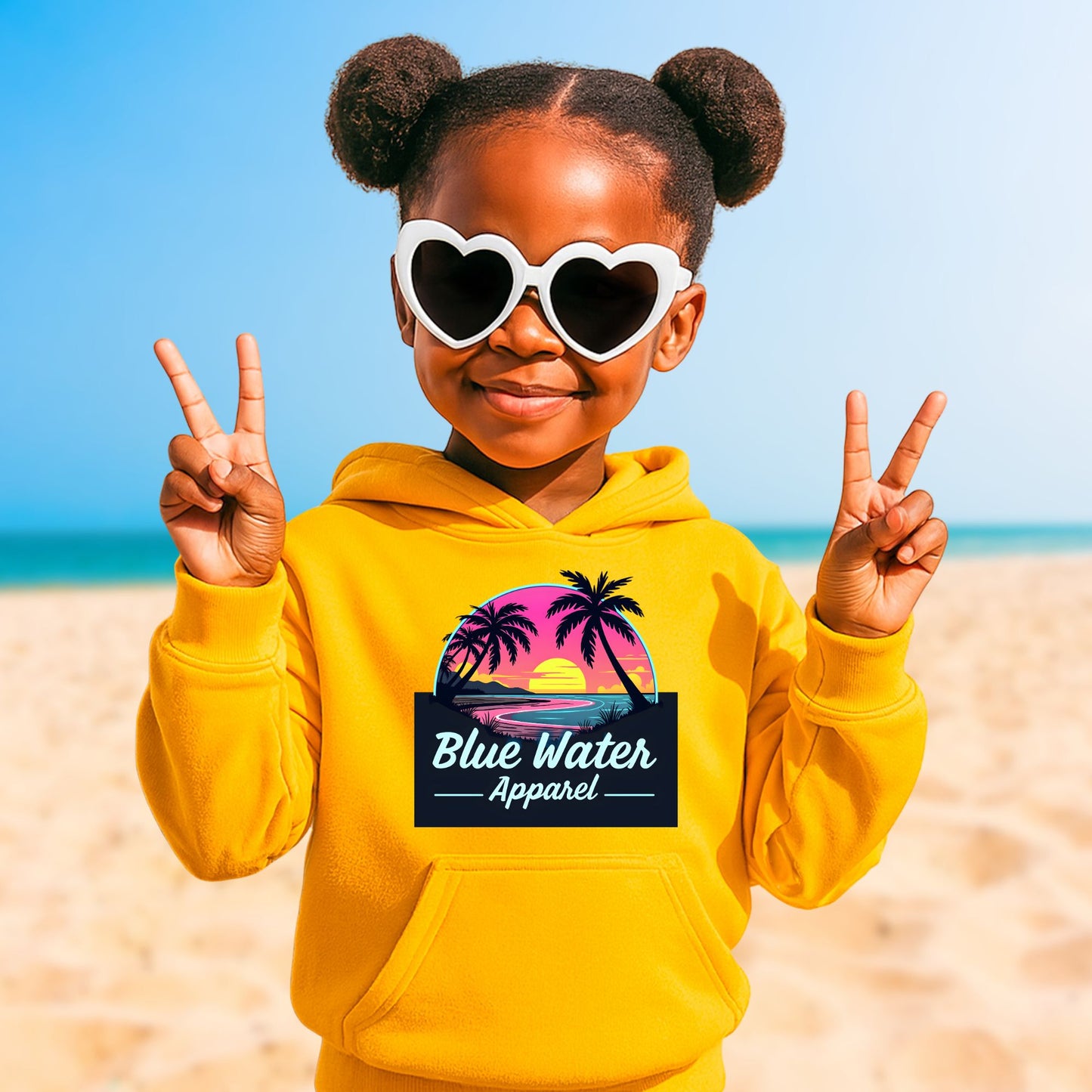 little girl on beach wearing gold neon sunset kids hoodie by blue water apparel