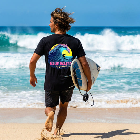 model wearing black neon surfer adult tee running with a surfboard on beach by blue water apparel