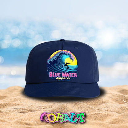 neon surfer cobalt surf cap sitting on beach by blue water apparel