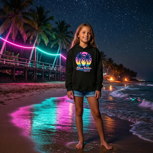 girl wearing black neon tropics hoodie on neon lit beach by blue water apparel