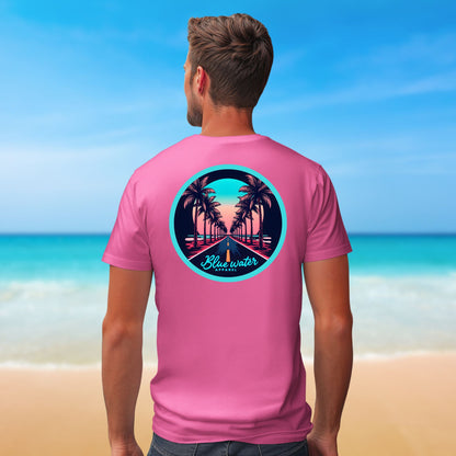 male model on beach wearing charity pink palm tree road tee by blue water apparel