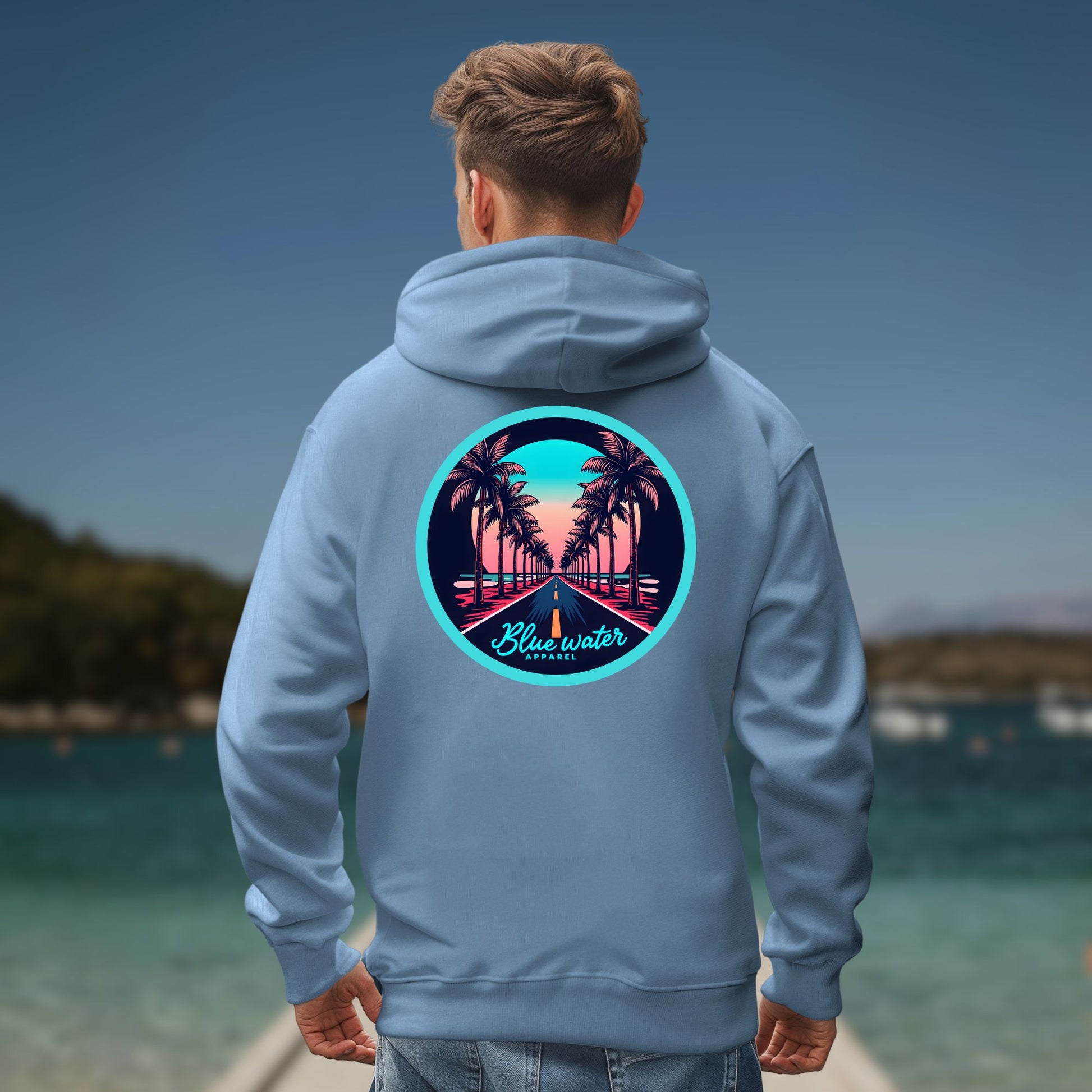 model on ocean pier wearing indigo blue palm tree road hoodie by blue water apparel
