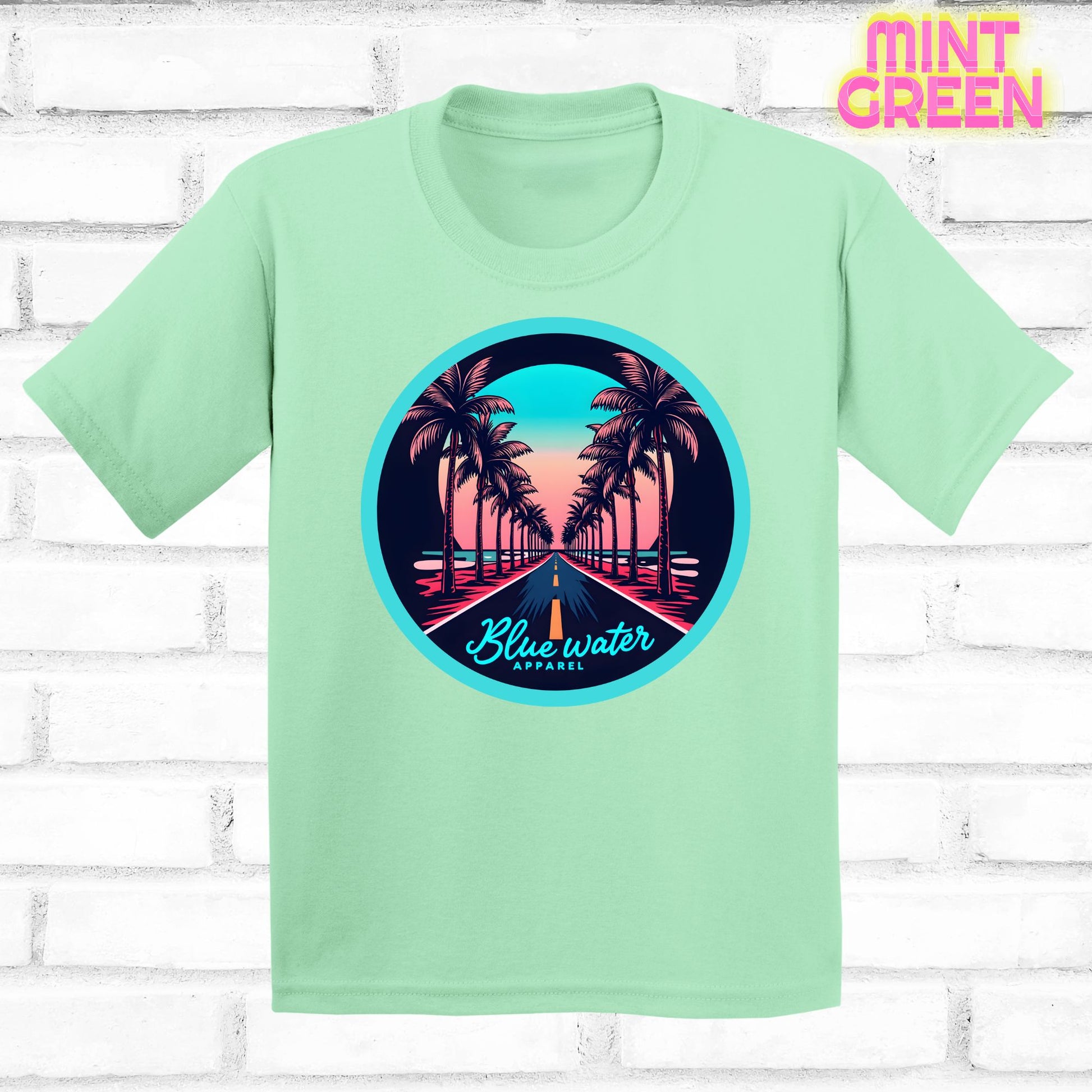 flat lay of mint green palm tree road tee by blue water apparel