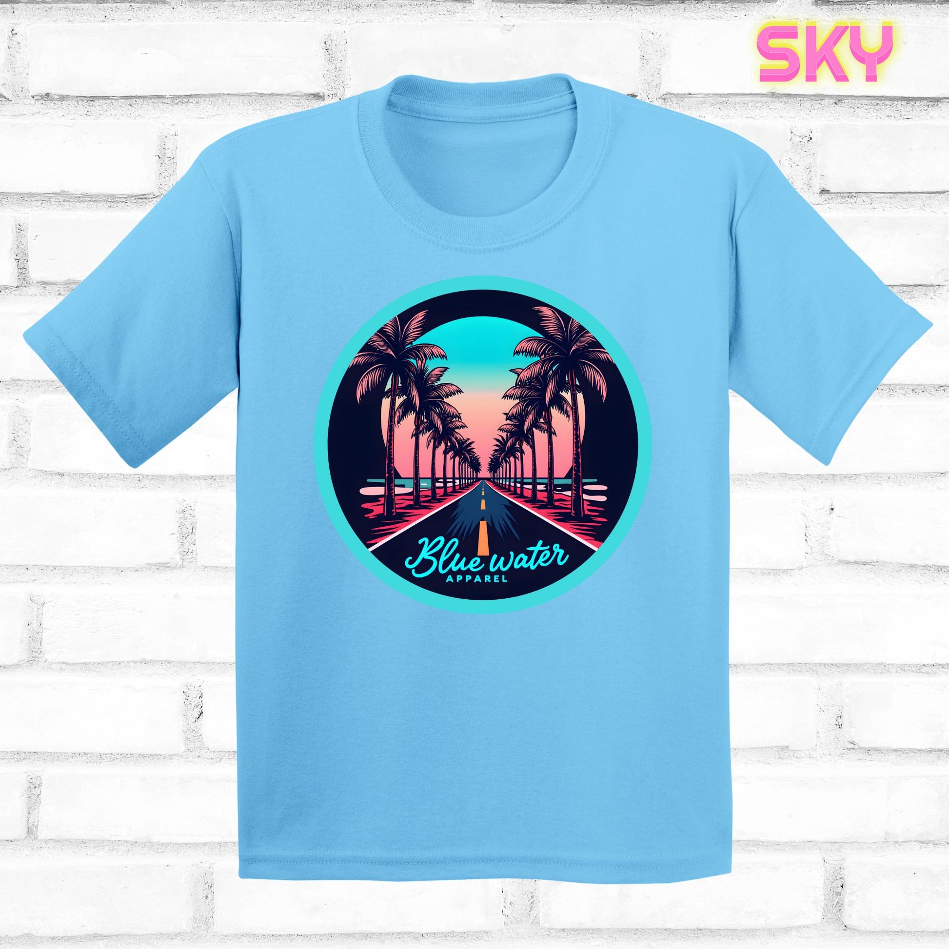 flat lay of sky palm tree road tee by blue water apparel