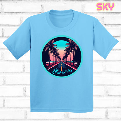 flat lay of sky palm tree road tee by blue water apparel