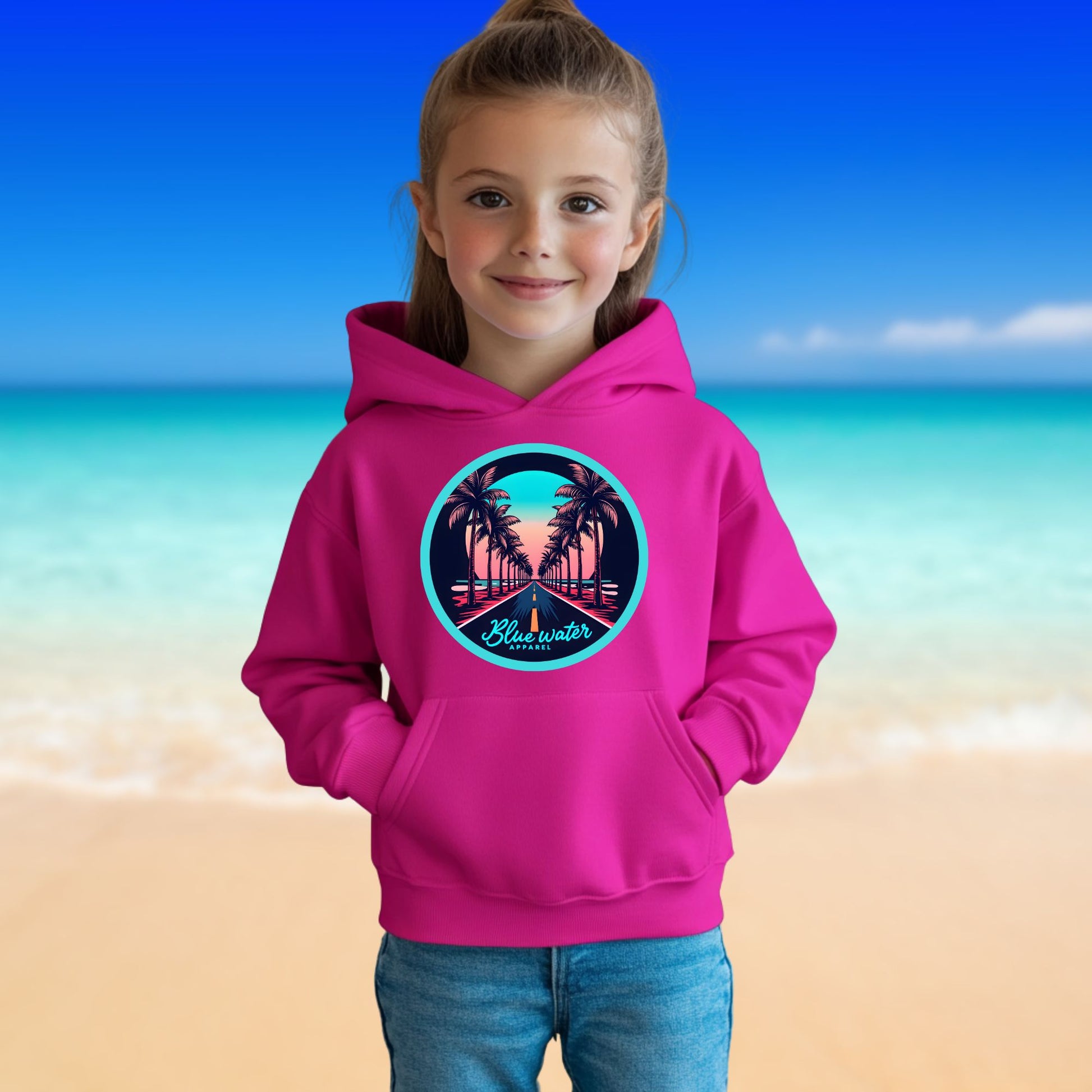 female model on beach wearing heliconia palm tree road kids hoodie by blue water apparel