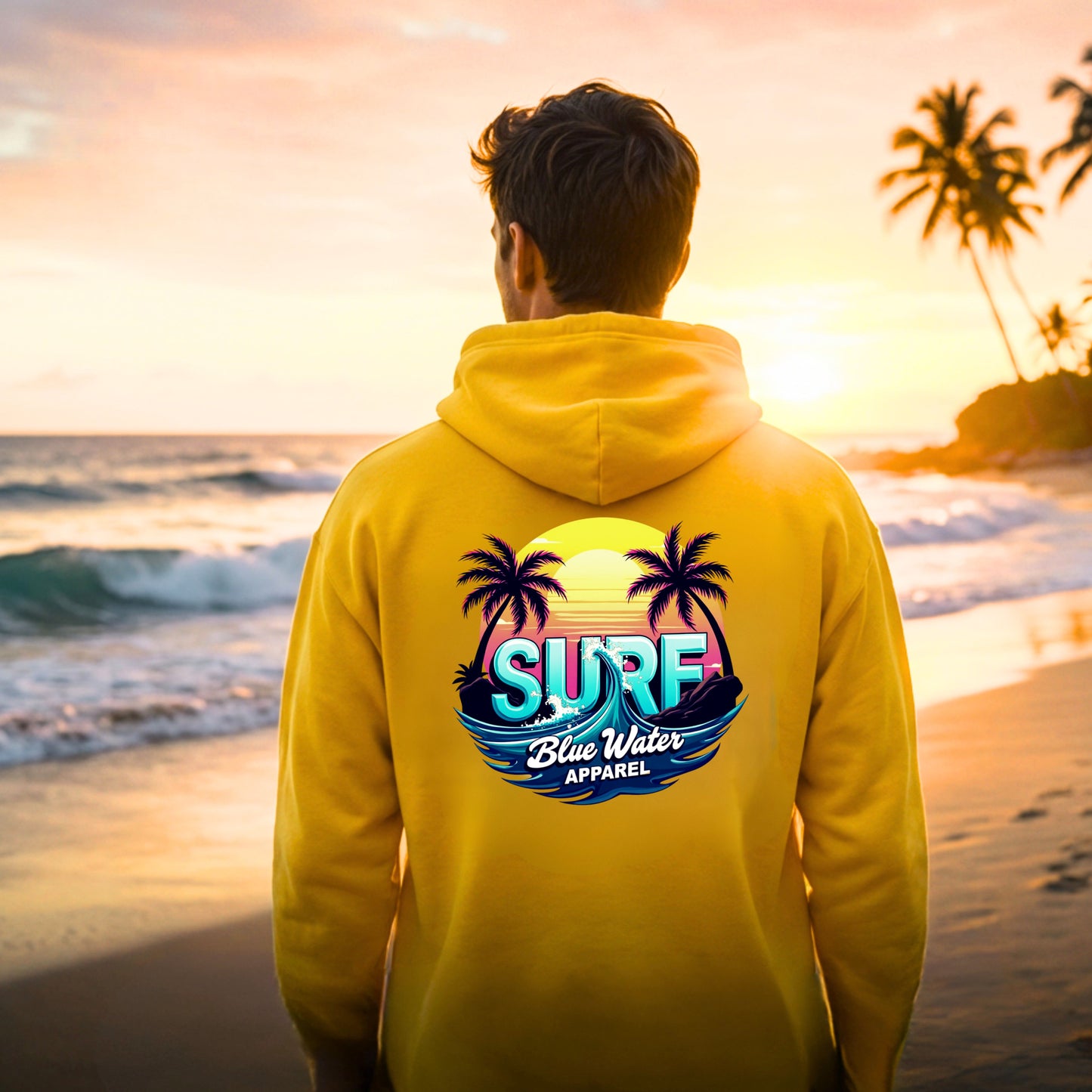 male model wearing gold retro surf adult hoodie on beach by blue water apparel