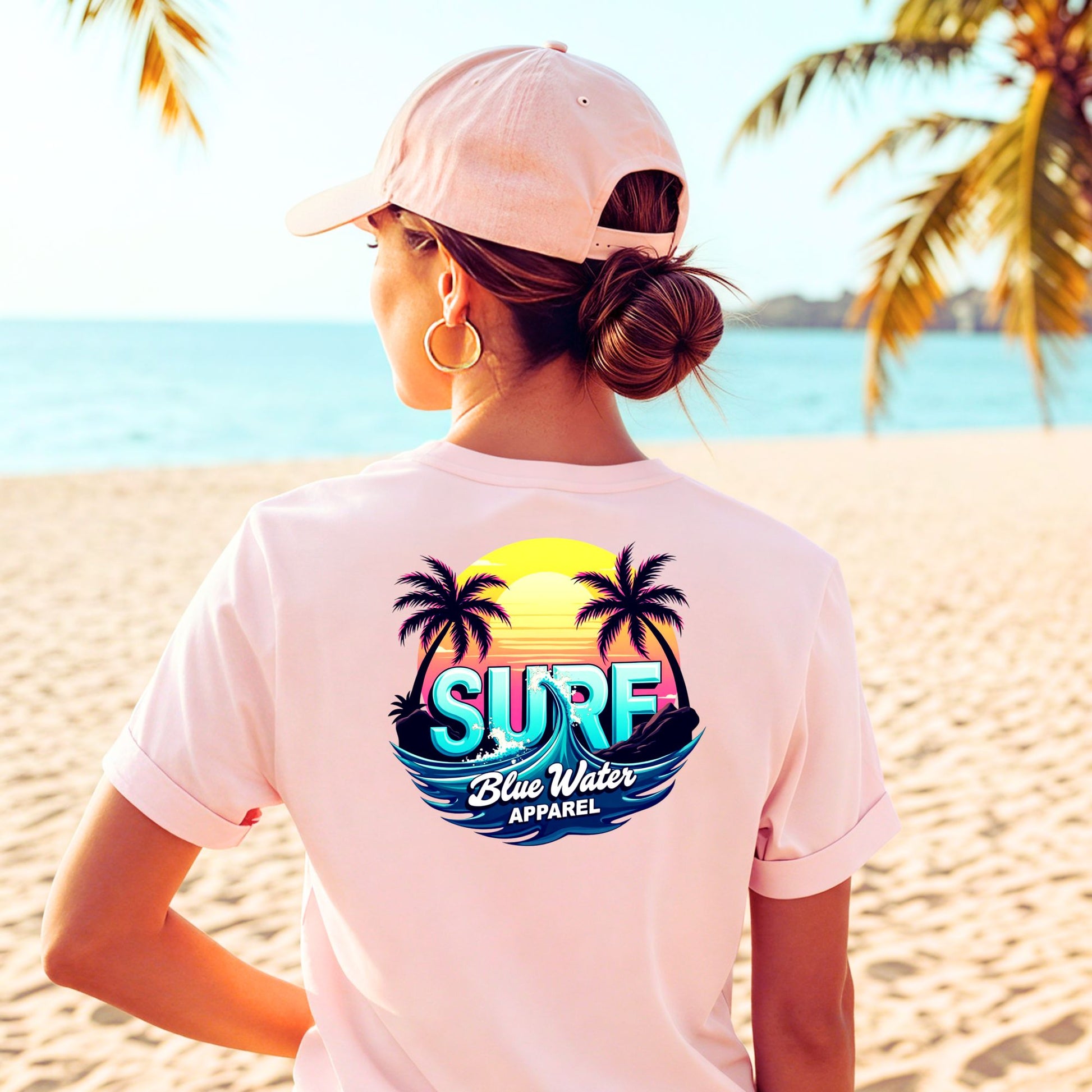 female model on beach wearing pink retro surf tee by blue water apparel