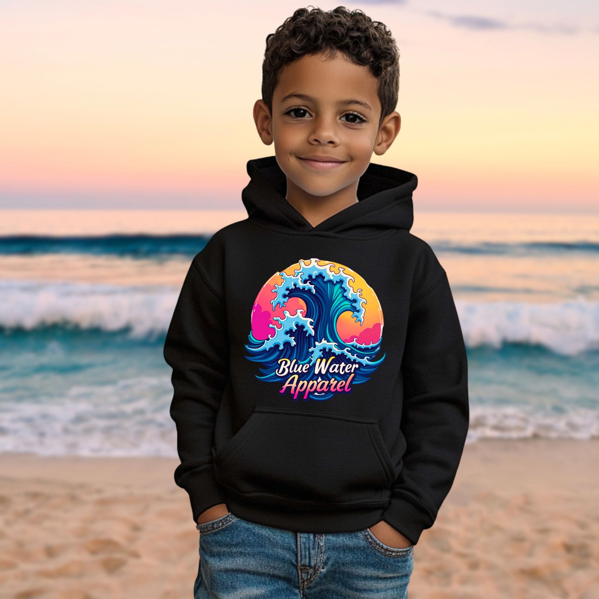 male model on beach wearing black retro wave kids hoodie by blue water apparel