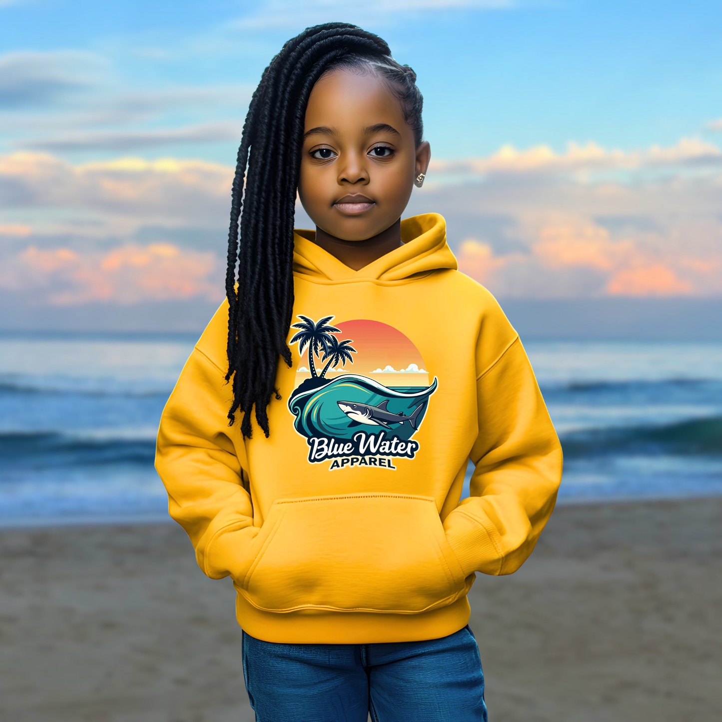child model on beach wearing gold shark wave kids hoodie by blue water apparel