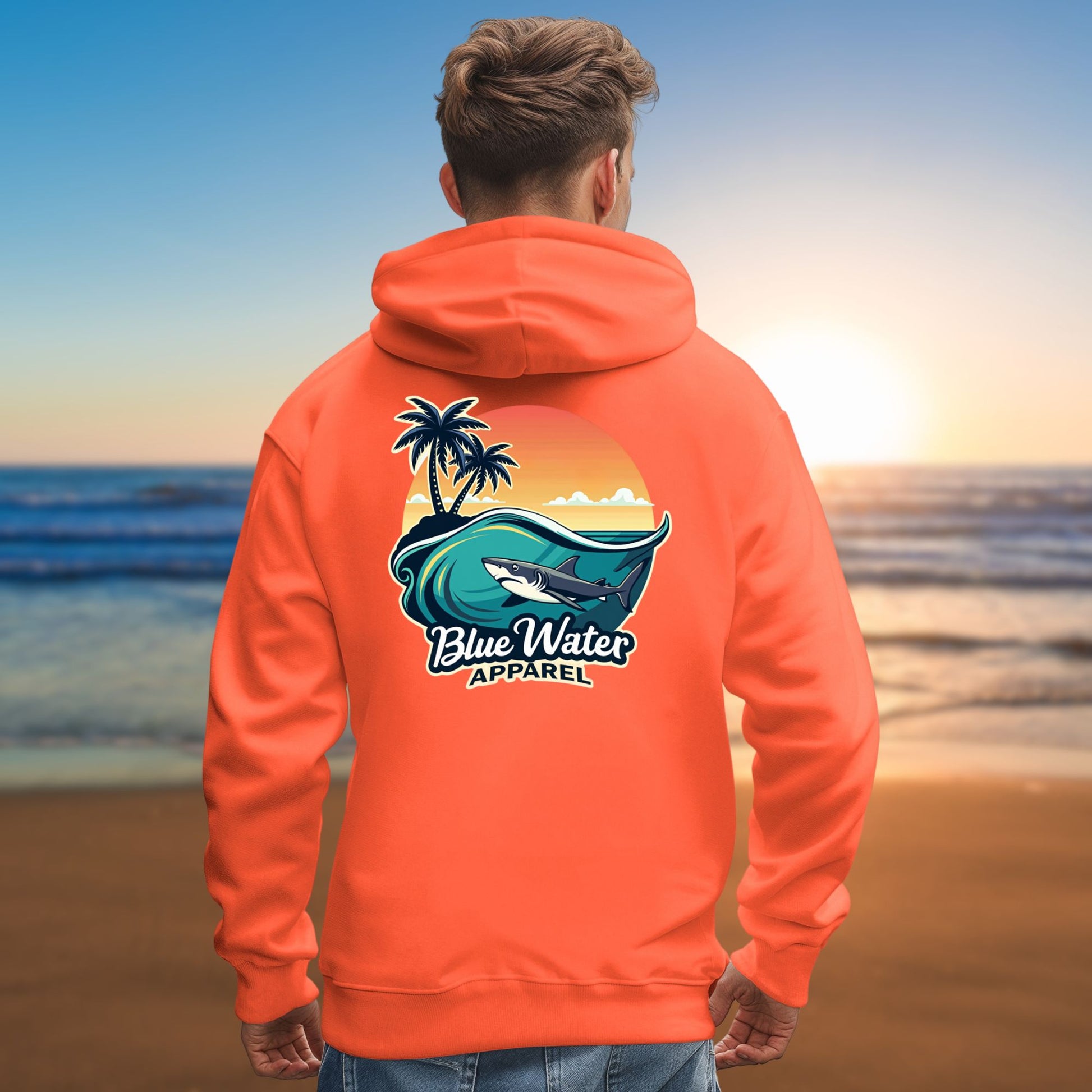 man gazing out over ocean wearing orange shark wave hoodie by blue water apparel