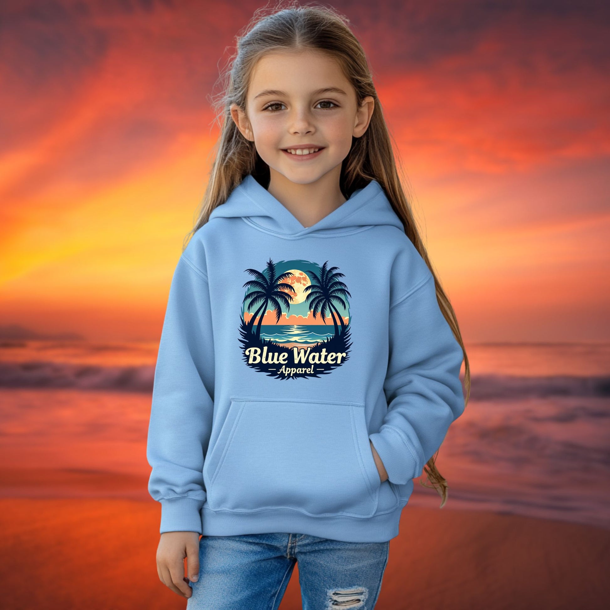 child model on beach wearing carolina blue tropical moon kids hoodie by blue water apparel