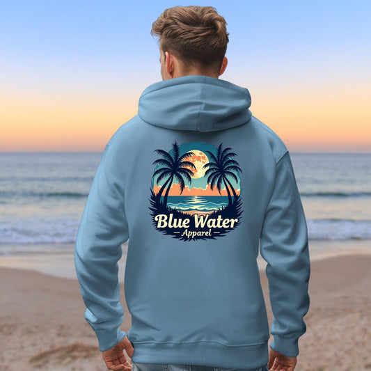 male model on beach wearing indigo blue tropical moon hoodie by blue water apparel