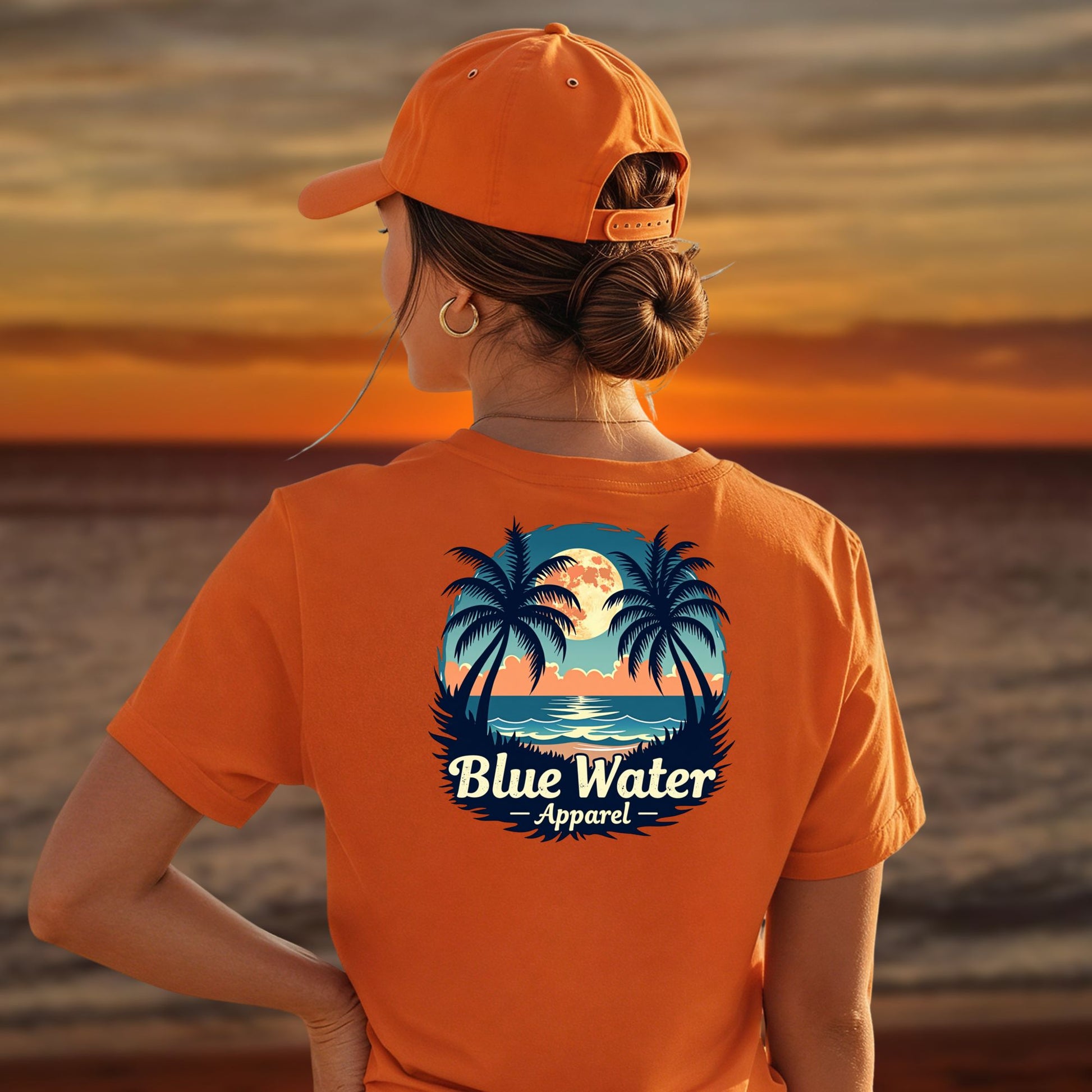 model on beach wearing orange tropical moon tee by blue water apparel
