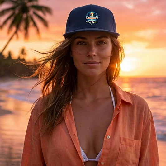 woman wearing petrol blue tropical moon surf cap on beach by blue water apparel