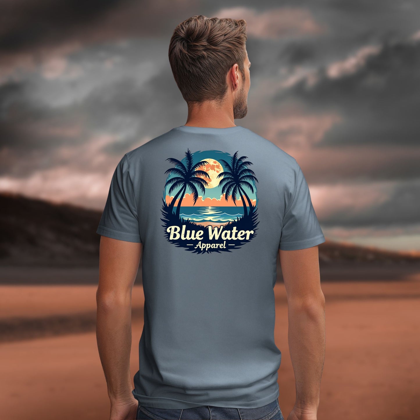 male model looking over ocean wearing steel blue tropical moon tee by blue water apparel