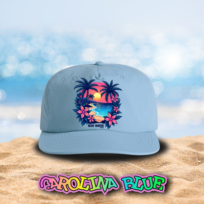 flat lay carolina blue tropical sunset surf cap on beach by blue water apparel
