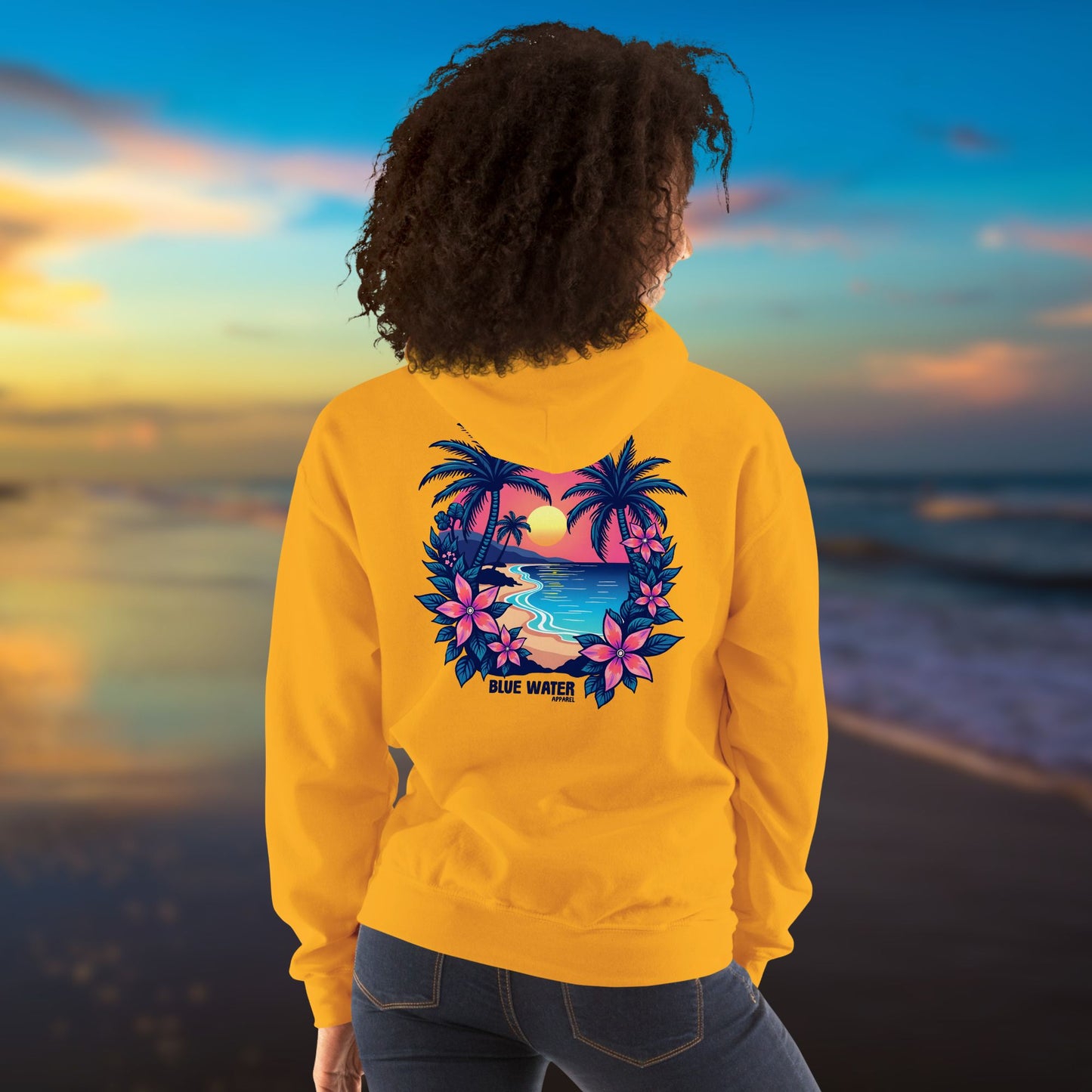 model on beach wearing gold tropical sunset hoodie by blue water apparel