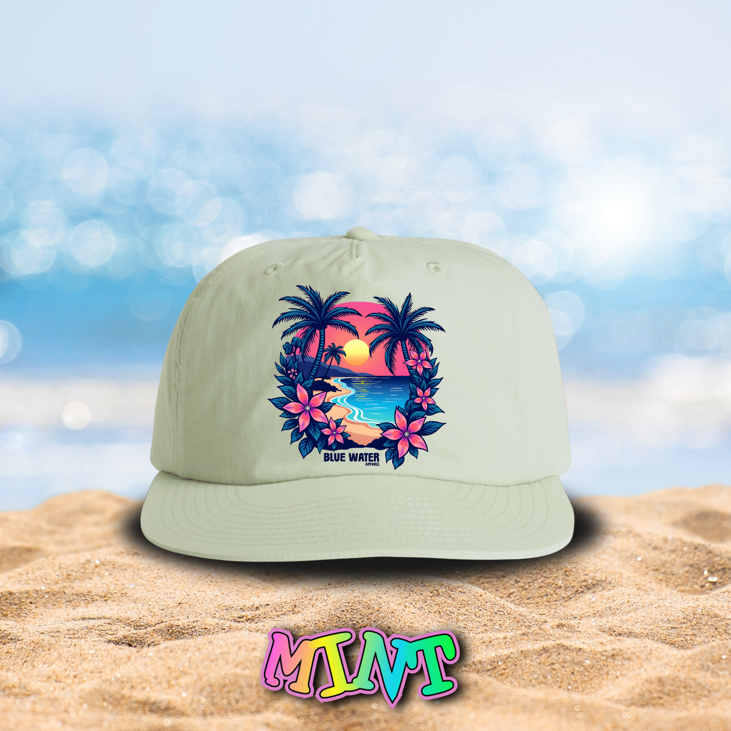 flat lay mint tropical sunset surf cap on beach by blue water apparel