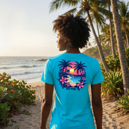 model wearing turquoise tropical sunset adult tee on beach path by blue water apparel