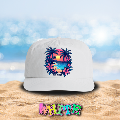 flat lay white tropical sunset surf cap on beach by blue water apparel