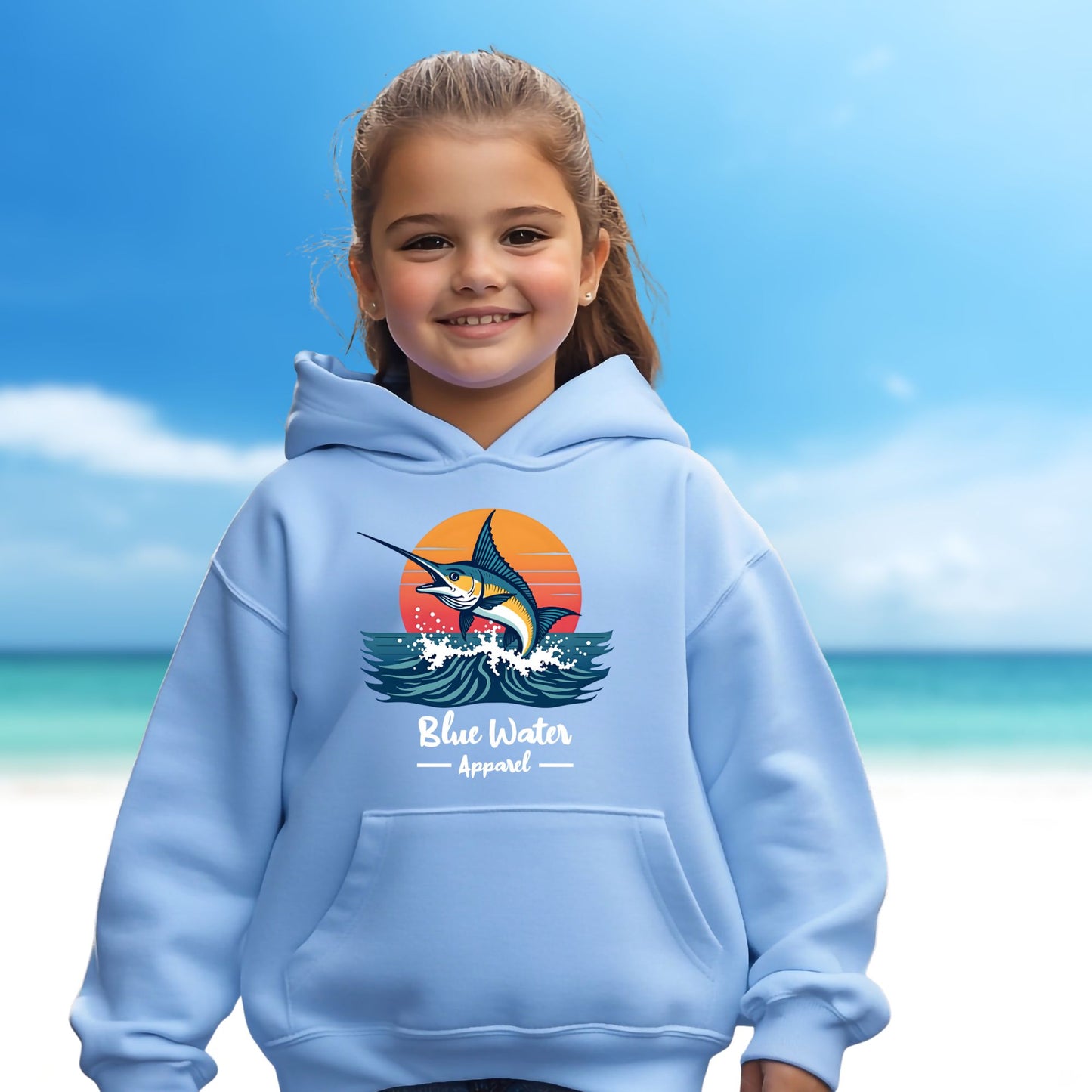 child model on beach wearing carolina blue vintage marlin kids hoodie by blue water apparel