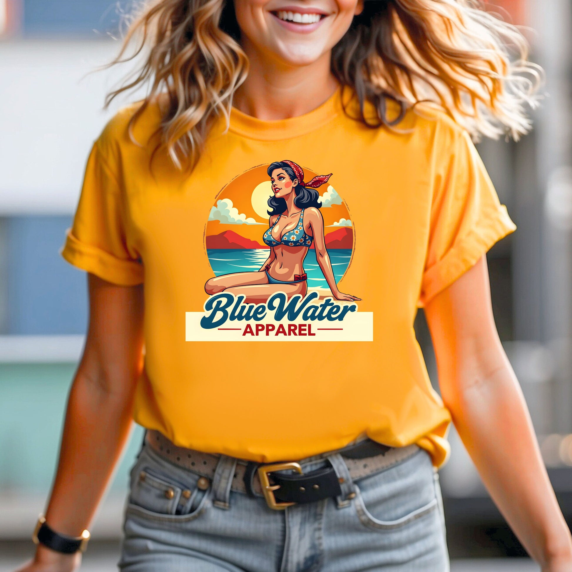 female model smiling wearing a gold vintage pin up graphic tee by blue water apparel