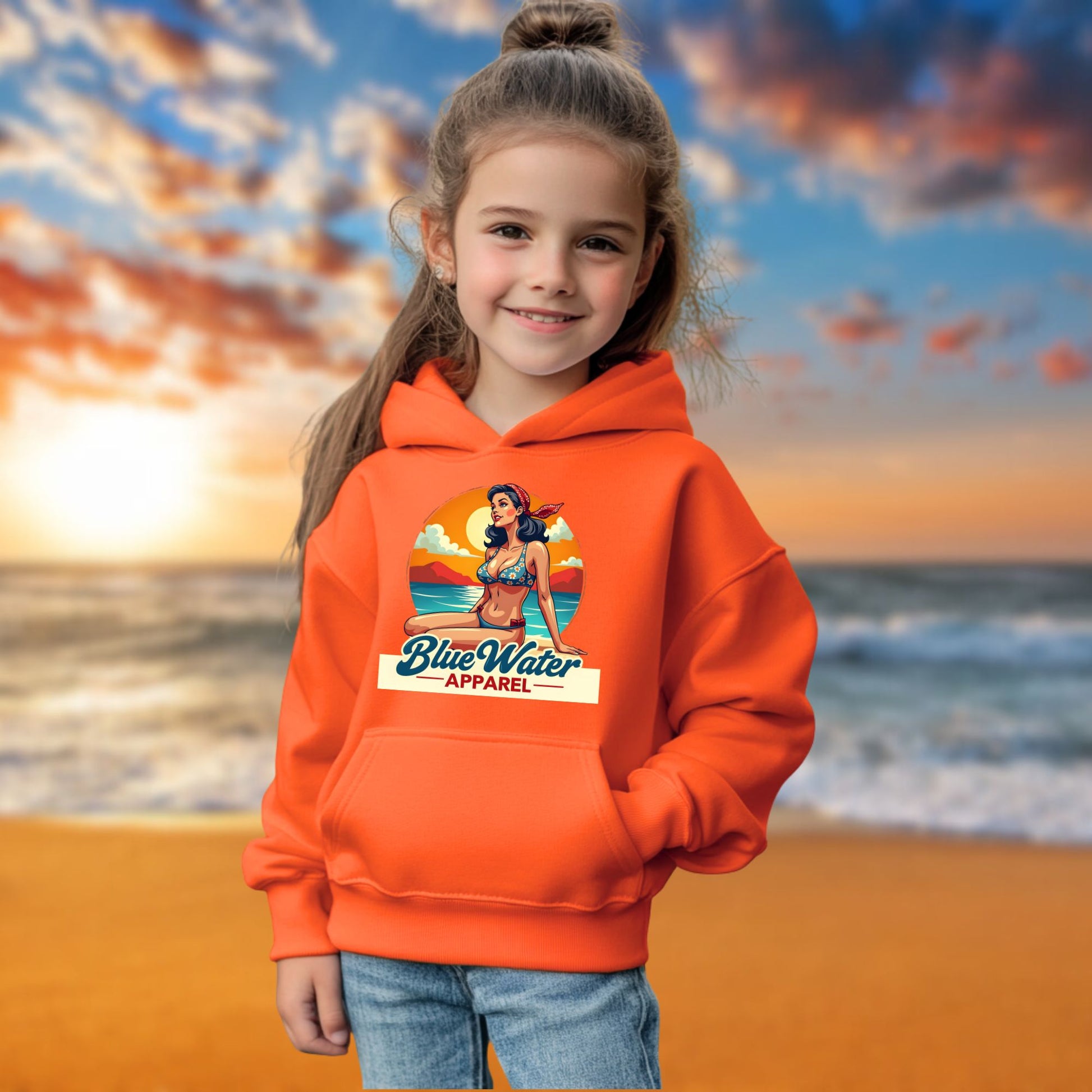 child model on beach wearing orange vintage pin-up kids hoodie by blue water apparel