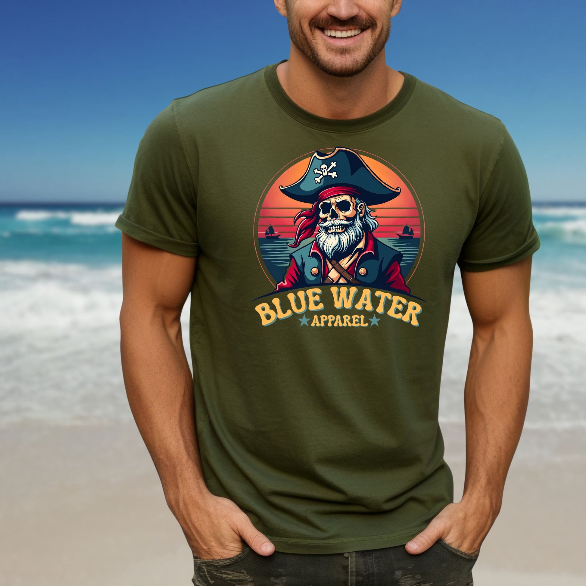 Model on beach wearing military green front graphic vintage pirate  tee by Blue Water Apparel