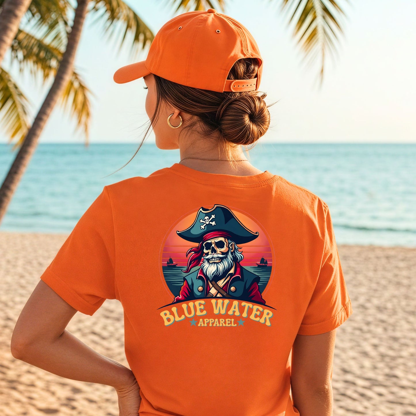 Model on beach wearing orange vintage pirate tee