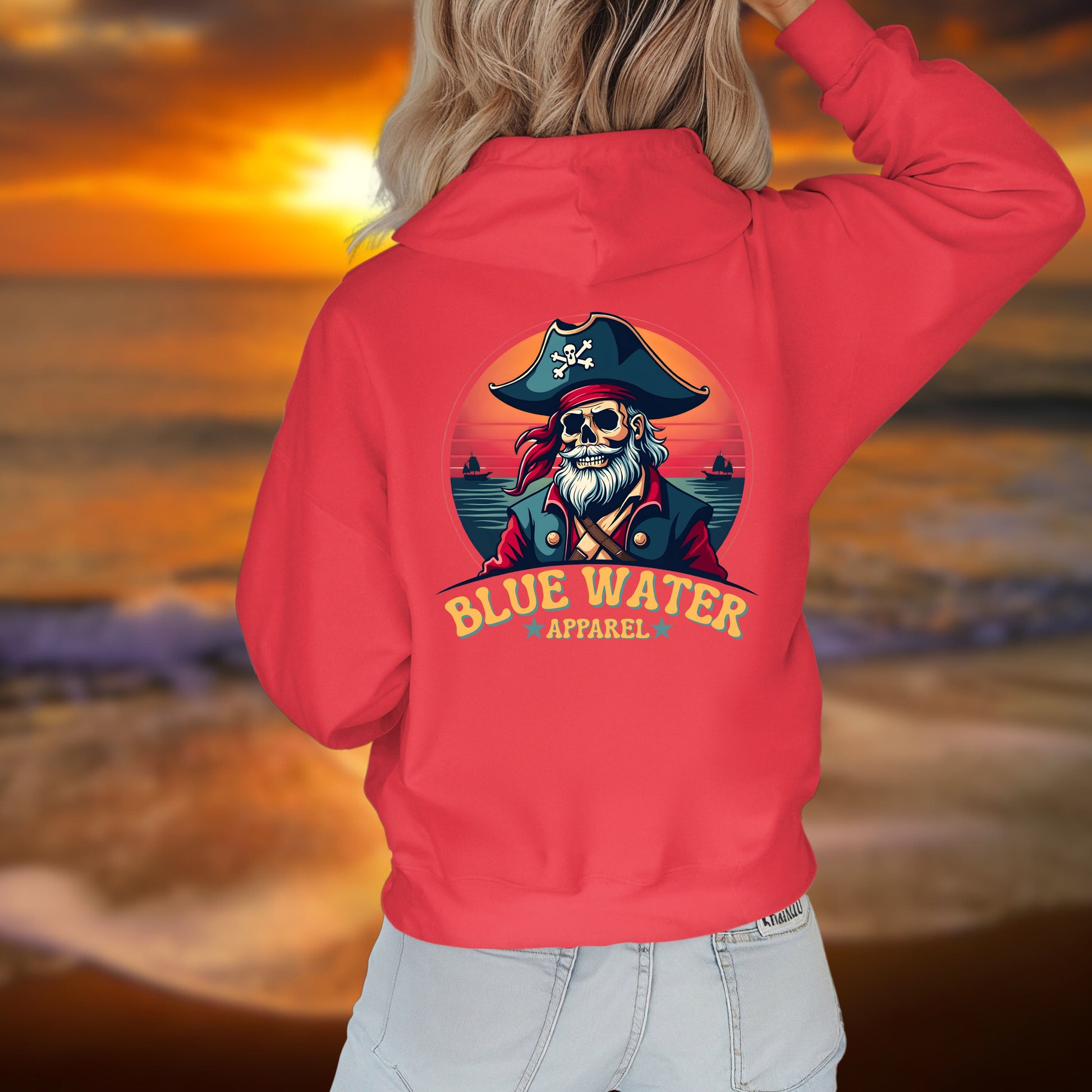 woman on beach wearing red vintage pirate hoodie by blue water apparel