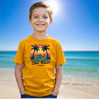 male child on beach wearing gold vintage sunset tee by blue water apparel