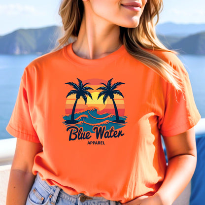 model wearing an orange vintage sunset tee by blue water apparel with beach background