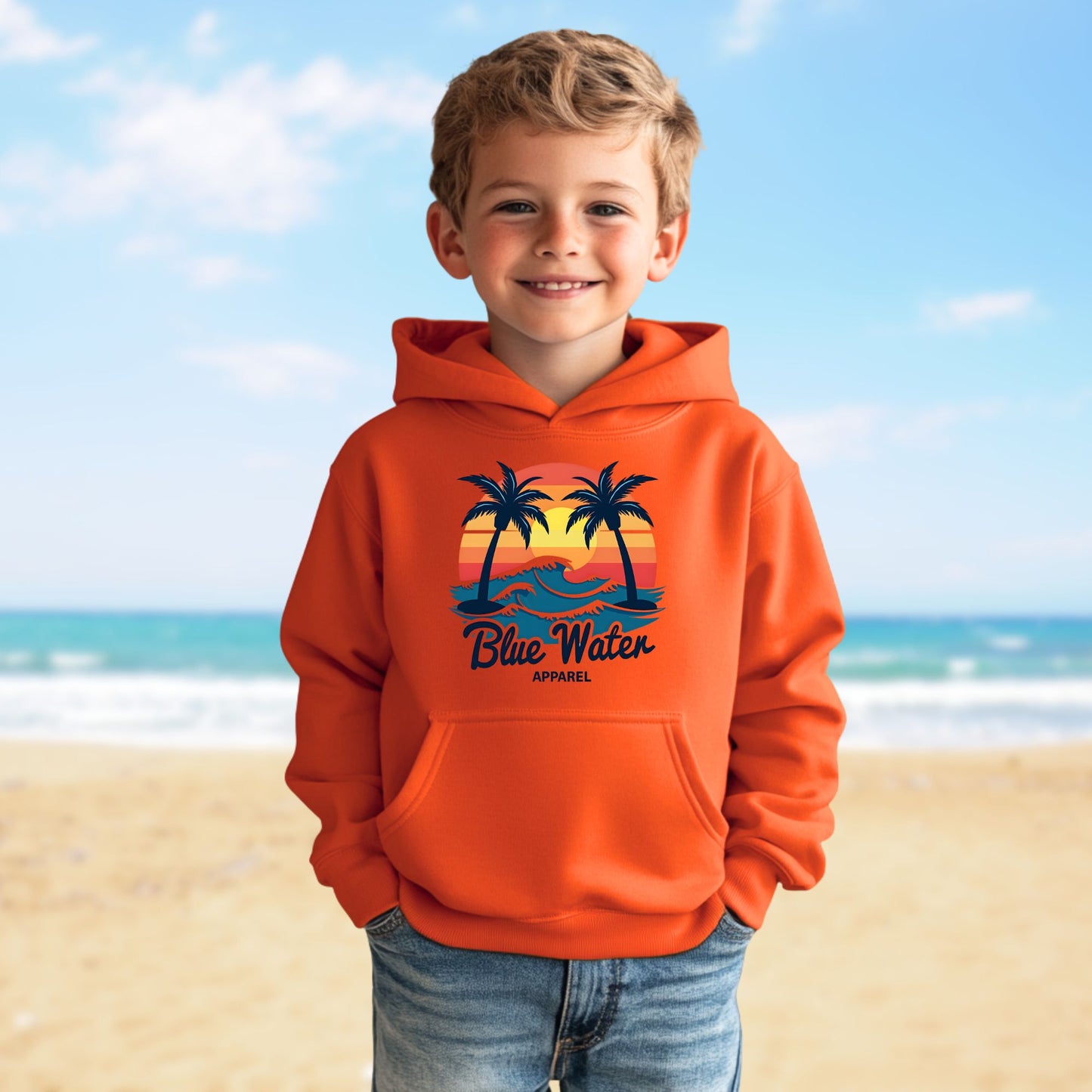 child model on beach wearing orange vintage sunset kids hoodie by blue water apparel