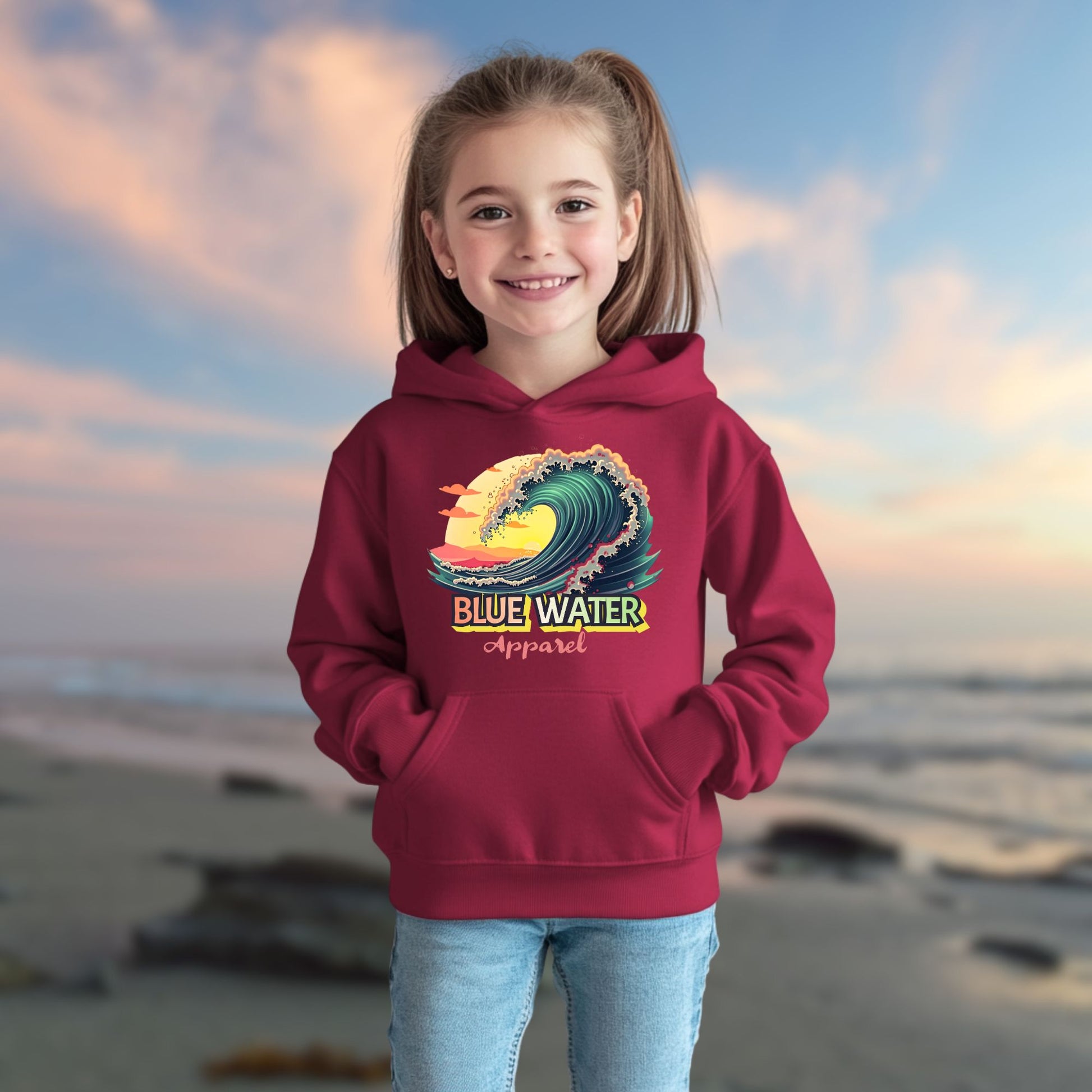 child model on beach wearing cardinal red vintage surf kids hoodie by blue water apparel