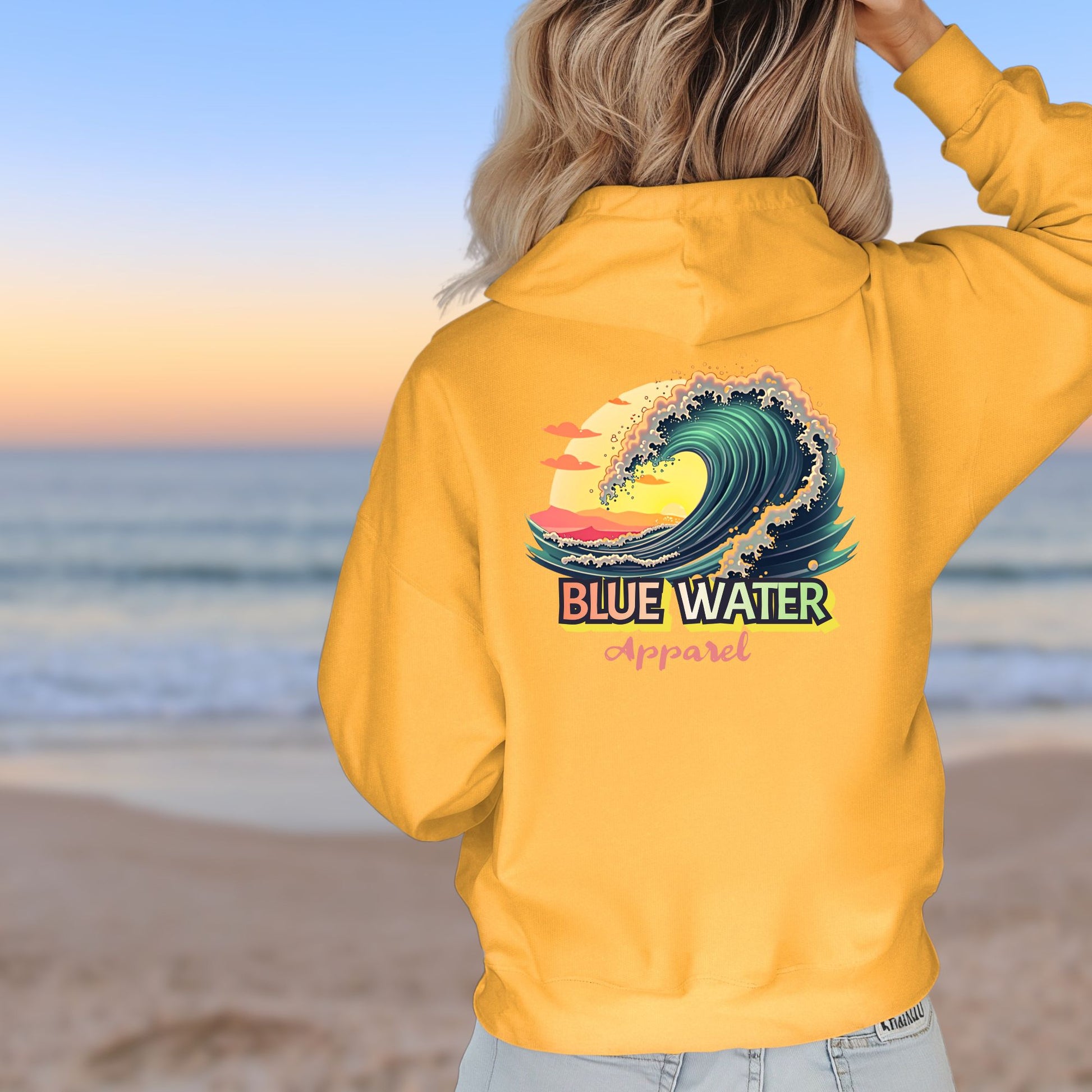 woman on beach wearing gold vintage surf hoodie by blue water apparel