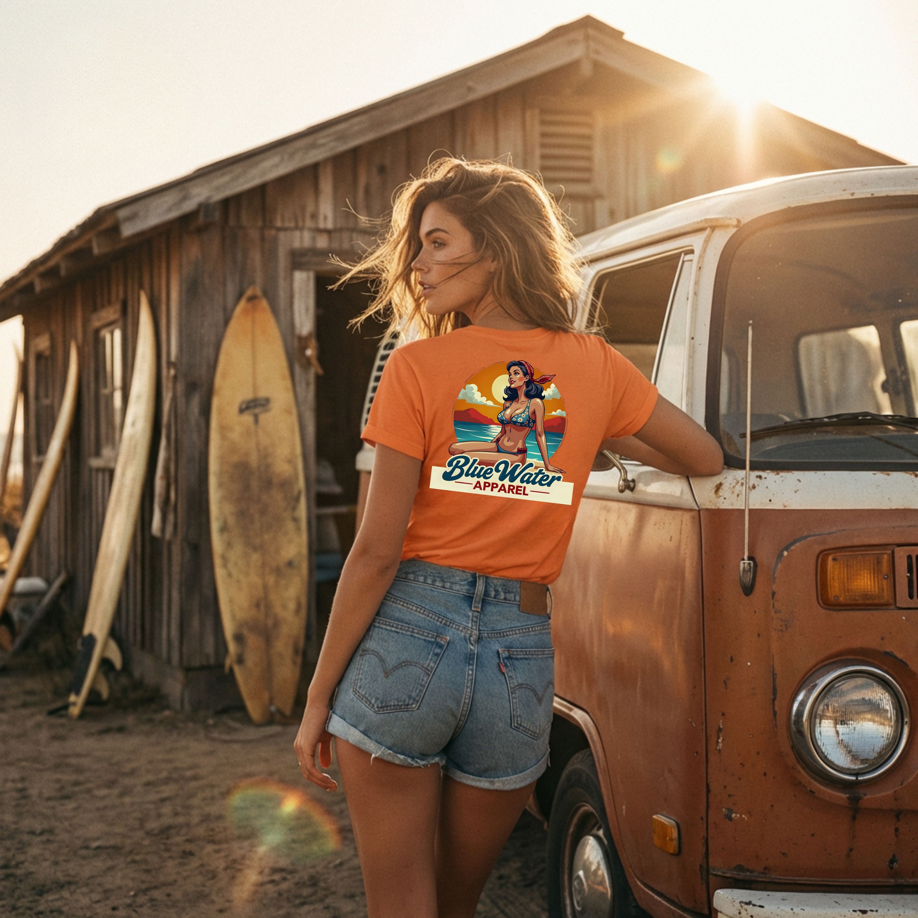 woman wearing orange vintage pin-up tee leaning on vw van at surf shack by blue water apparel