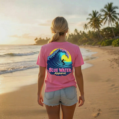 music video of model wearing charity pink neon surfer adult tee standing on beach by blue water apparel
