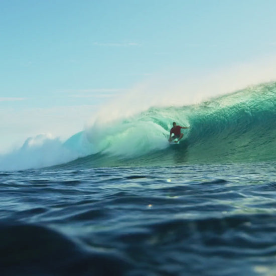 music video of surfer in curl wave featuring the hibiscus wave graphic by blue water apparel